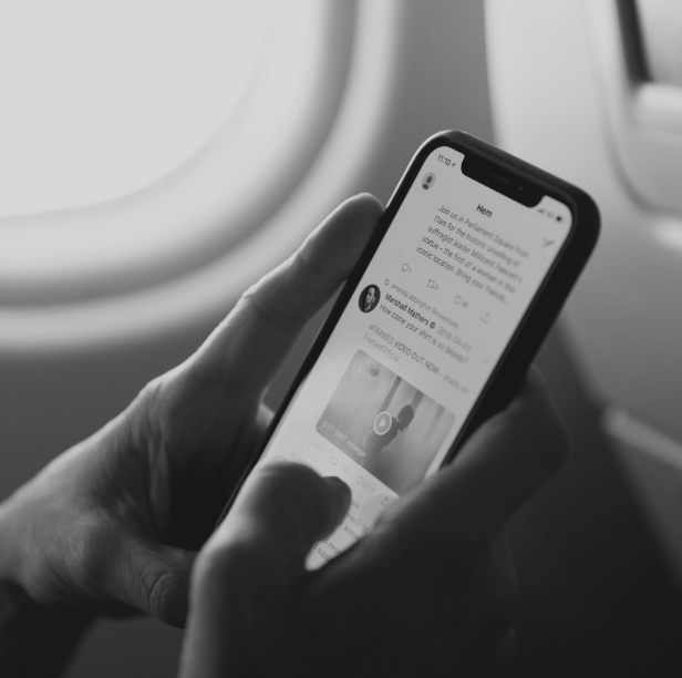 Hand holding a phone showing a social media profile