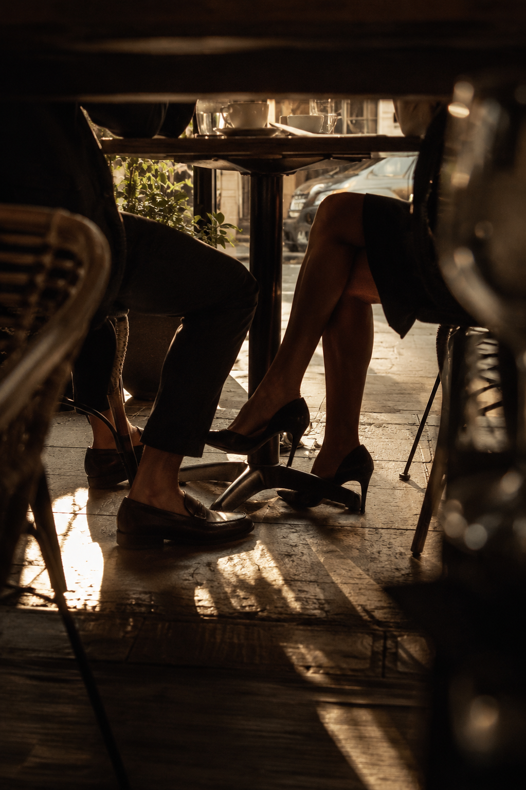 Legs of a couple seen beneath a cafe table in evening light couple are in a relationship investigation